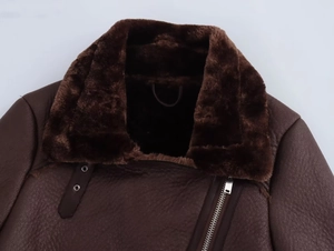 Détail du col en fausse fourrure marron et de la veste en cuir avec fermeture éclair métal