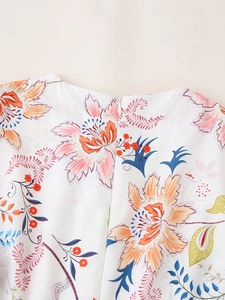 Detailaufnahme des verdeckten Reißverschlusses am Rücken eines weißen Blumenkleides