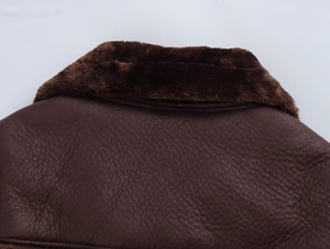 Détail du col en fausse fourrure marron et de la texture cuir de la veste pour femme