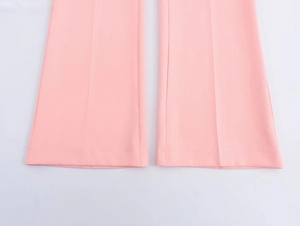 Dettaglio dei pantaloni a zampa rosa che mostra le cuciture e la piega centrale stirata