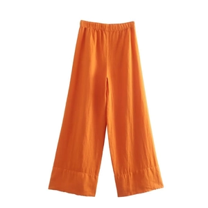 Détail du pantalon large en lin orange avec taille haute élastique et coutures soignées