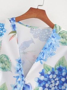 Close-up of V-neck floral dress with blue hydrangea print, bird motifs and size S tag