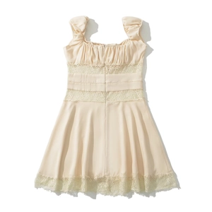 Detail of elegant beige dress featuring intricate lace cut-outs and pleated square neck