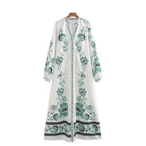 Detailed view of V-neckline and vintage green floral print on white long dress