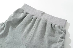 Detail of gray athletic shorts featuring elastic ribbed waistband and heather knit texture