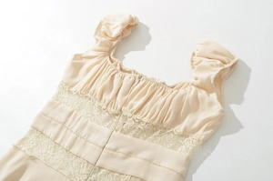 Detailed close-up of beige lace panels and ruched bodice on a summer dress