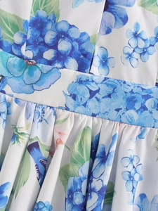 Detailed macro view of the waist belt stitch and blue floral bird print on white fabric