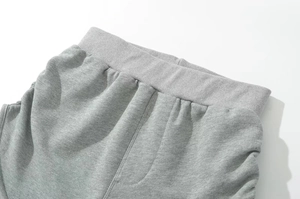 Detail of the elastic ribbed waistband with reinforced stitching on gray shorts