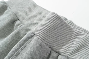 Macro detail of the gray ribbed knit elastic waistband on these casual summer shorts