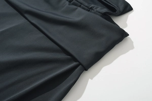 Makro-Detail der Taillennaht und der hochelastischen Stoffstruktur der schwarzen Slim-Hose
