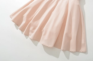 Detail of light pink pleated skirt hem with soft lace fabric and delicate drape effect