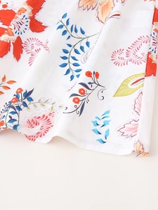 Detaillierte Makroansicht des feinen Rollsaums an einem Kleid mit Vintage-Blumendruck