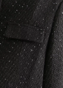 Gros plan sur le tissu en tweed noir aux paillettes argentées avec détail de la poche
