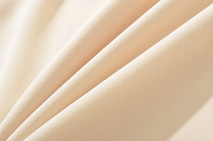 Macro shot of apricot chiffon crepe fabric showing elegant drape and fine texture