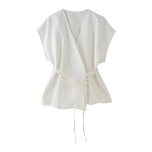 Dettaglio del gilet in lino bianco con chiusura a portafoglio e scollo a V elegante