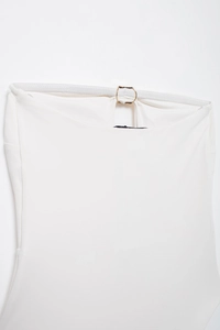 Dettaglio costume da bagno bianco a fascia con anello in metallo dorato e fascia elastica