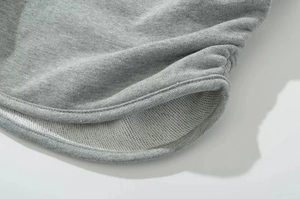 Detail of light gray French Terry fabric with side pleats and flatlock stitching