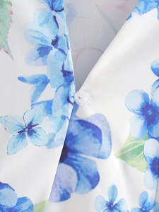 Detail of floral print summer dress with small transparent button and fabric texture