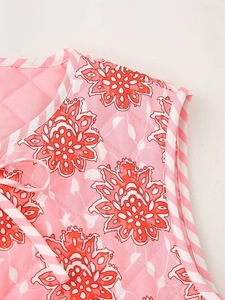 Detalle de chaleco acolchado rosa con estampado floral y ribete a rayas con cordones