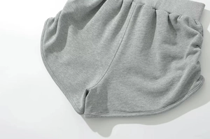 Detail of grey knitted shorts showing elastic waistband and dolphin hem stitching