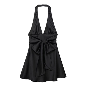 Dettaglio di mini abito nero in raso con scollo all'americana e grande fiocco in vita