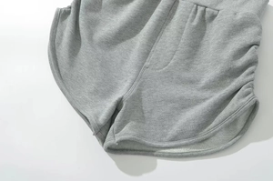 Detail of heather grey knit shorts with curved hem and ribbed waist stitching