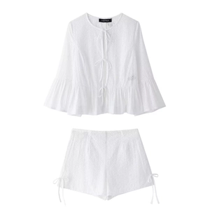 Détail d'un ensemble d'été blanc en broderie anglaise avec broderie ajourée et liens