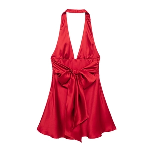 Dettaglio dell'abito halter in raso rosso con grande fiocco frontale e scollo a V