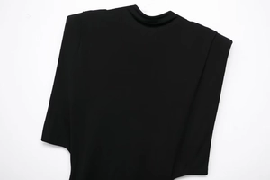 Détail des épaulettes sur une robe en maille noire moulante avec col montant élégant