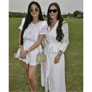 Detailed embroidery and eyelet patterns on white midi dress with ruffles and waist tie