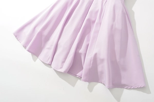 Detailed close-up of light purple lace dress hem with smooth stitching and soft drape fabric