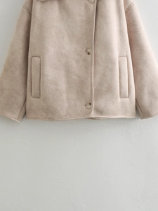 Detail of faux suede jacket with side pockets and large white buttons in beige