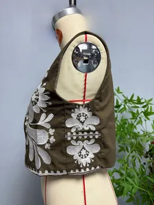 Détail de la broderie florale blanche sur gilet sans manches marron vintage