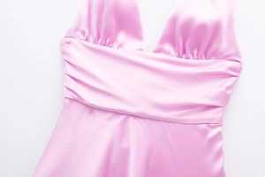Dettaglio dell'abito allacciato al collo in raso rosa con petto a pieghe e seta fine