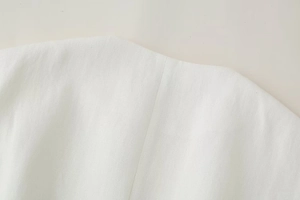 Dettaglio del gilet bianco in misto lino con trama saia e cuciture di precisione