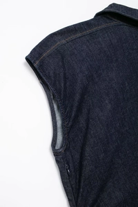 Détail d'une robe midi en jean avec fermeture éclair invisible et surpiqûres orange