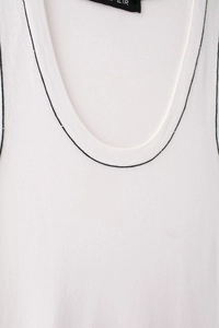 Detail of white knit tank top with contrast black stitching on the neckline and armhole