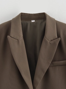 Detail of dark brown short blazer showing lapel collar texture and size S woven label