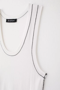 Detail of white knit tank top with contrast black stitching and woven brand label