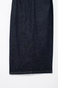 Détails des surpiqûres jaunes sur l'ourlet d'une robe en denim bleu indigo foncé