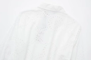 Detail of white cotton midi dress with intricate floral eyelet embroidery and classic collar