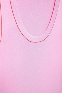 Detail of pink knitted tank top with contrasting red trim at the neckline and armholes