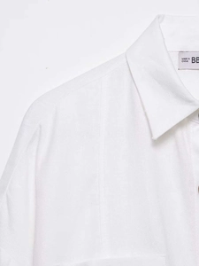 Detail of white cotton linen shirt showing the lapel collar and premium fabric texture
