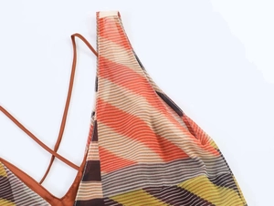 Detail of V-neck summer dress featuring colorful geometric patterns and thin orange straps