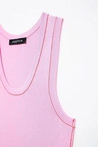 Detail of pink knit vest featuring contrast red stitching and brand label at the neckline