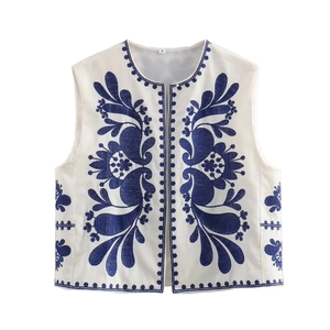 Détail de la broderie de la veste blanche sans manches avec motifs floraux marine