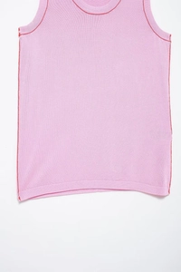 Detail of pink knit vest featuring contrast red stitching on neckline and armholes