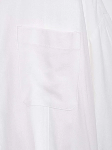 Close-up of a white cotton-linen loose shirt featuring a square chest pocket detail