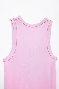 Detail of pink ribbed knit tank top with red contrast stitching at the neckline and armholes