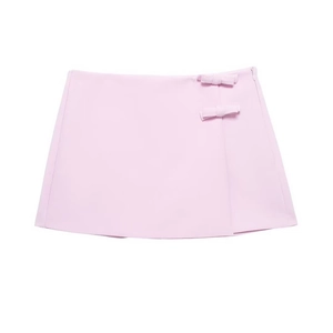 Détail d'une mini-jupe rose clair avec nœuds décoratifs latéraux et fermeture invisible
